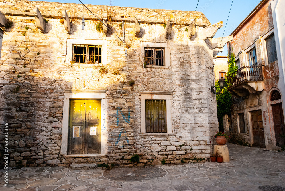 An old house and an alley bathed in sunlight in Greece