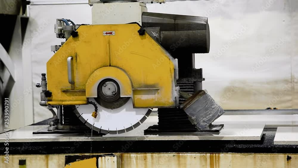 An automated machine lifting and moving a granite countertop from a cutting bench at a factory. Medium shot. An automated machine lifting and moving a granite countertop from a cutting bench at a factory. Medium shot.
