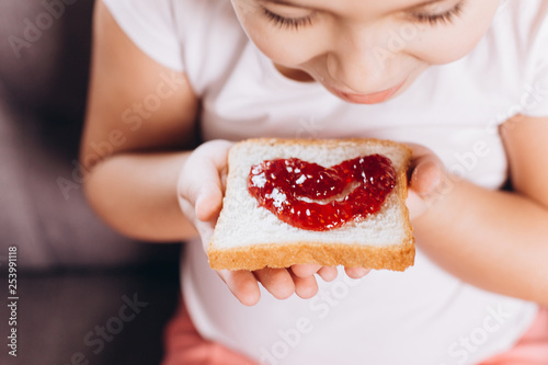 Children hand's holding sandwich with jam 