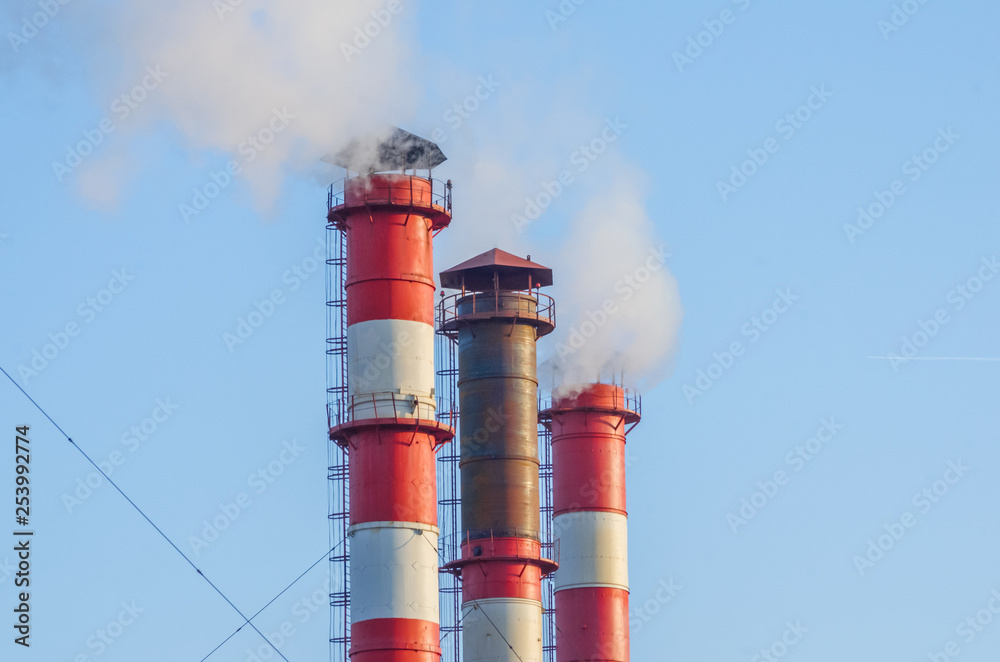smoke, emissions from three industrial pipes against the blue sky. Aircraft in the distance smoke, emissions from three industrial pipes against the blue sky. Aircraft in the distance