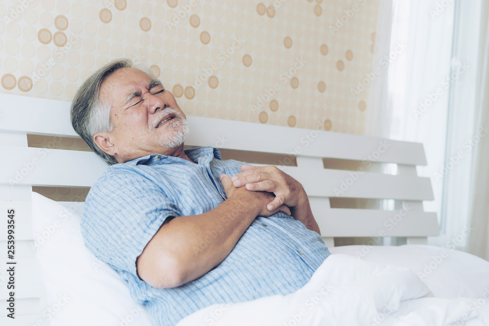 Senior male asian suffering from bad pain in his chest heart attack at home - senior heart disease Senior male asian suffering from bad pain in his chest heart attack at home - senior heart disease