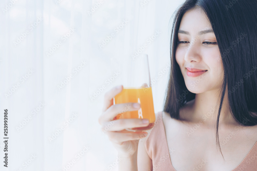 Beautiful beauty woman Asian cute girl feel happy drinking orange juice for good health in the morning , enjoying time in her home white bedroom background - lifestyle beauty woman concept Beautiful beauty woman Asian cute girl feel happy drinking orange juice for good health in the morning , enjoying time in her home white bedroom background - lifestyle beauty woman concept