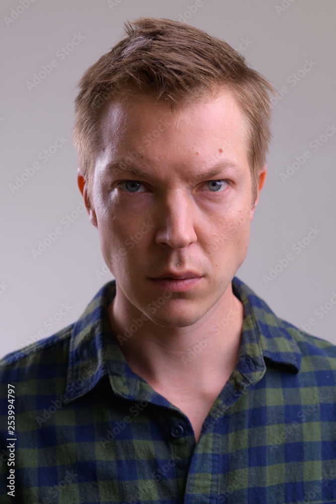 Obraz premium Face of young handsome hipster man against white background