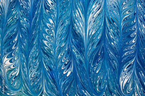 Beautiful abstract drawing technique Ebru in blue .Turkish style of painting Ebru on water with acrylic paints swirls waves.A stylish combination of natural luxury