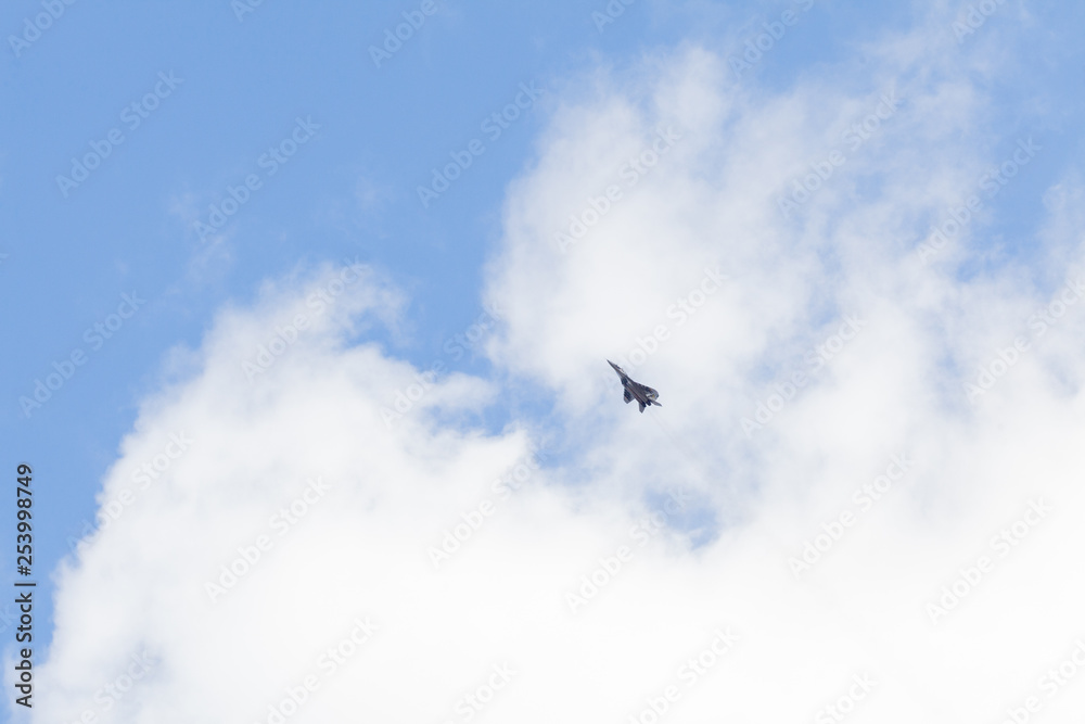 Military fighter in the blue sky with white clouds