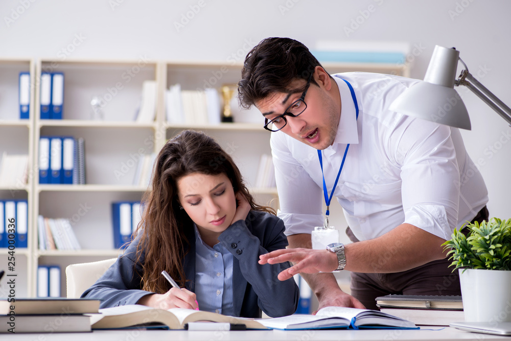 Teacher explaining to student at lecture Teacher explaining to student at lecture