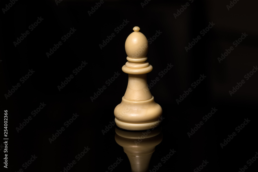 Classic Chess White Bishop on black board, isolated Classic Chess White Bishop on black board, isolated