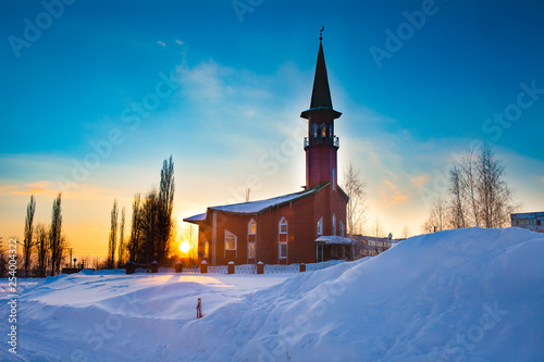 A small mosque of red brick. Winter. Sunset