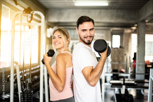 Portrait Fitness coaches are controlling the training equipment,Dumbbell Triceps Extension The Triceps are powerful,beautiful young girl warming up with weights in Gym health club