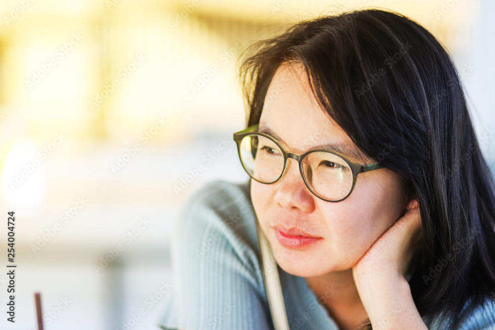 Half body shot Asian woman putting on eyeglasses