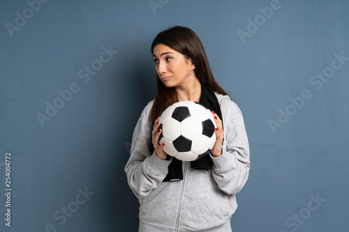 Young sport woman holding a soccer ball © luismolinero