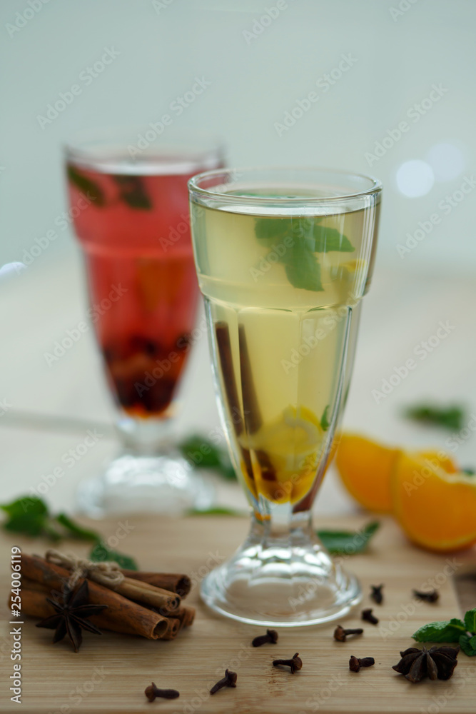 two glasses with colored hot drinks from which steam comes. winter hot seasonal vitemin drinks two glasses with colored hot drinks from which steam comes. winter hot seasonal vitemin drinks