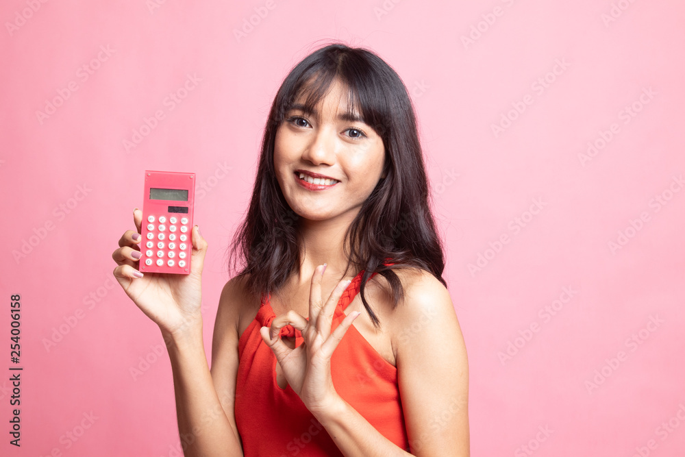 Asian woman show OK with calculator. Asian woman show OK with calculator.