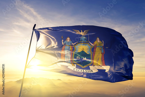 New York state of United States flag waving on the top sunrise mist fog photo