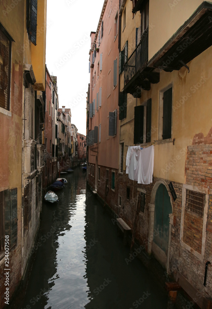 cloths over a waterway with boats in the island of Venice in Ita