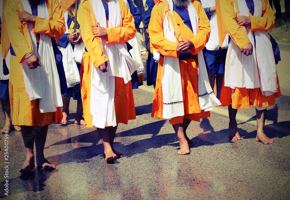 barefoot Sikh religion men during the parade in the city streets