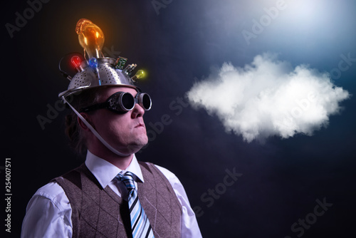 distraught looking conspiracy believer in suit with aluminum foil head with chemtrails cloud chemtrail