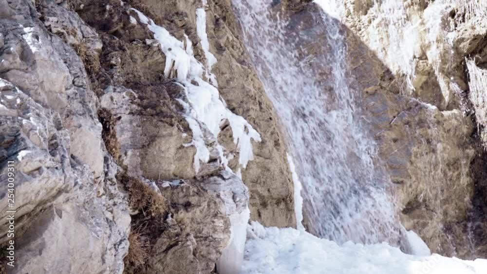 SLOW MOTION: waterfall flowing down in snow SLOW MOTION: waterfall flowing down in snow