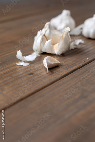 Garlic Bulb and Cloves on a Wooden Table; One Isolated in Front