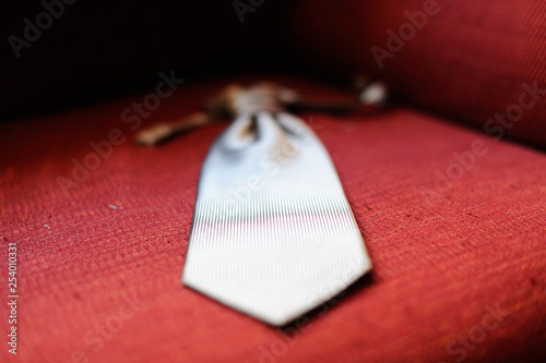 Corbata plateada con bokeh sobre tela roja