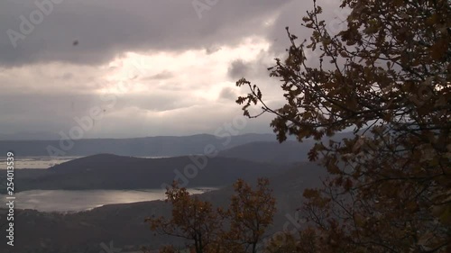 general shoot of a lake from above with automn leaves in front photo