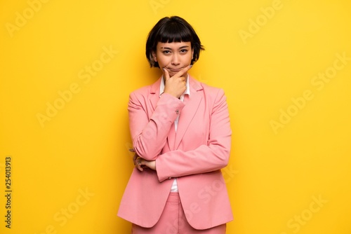 Modern woman with pink business suit smiling and looking to the front with confident face