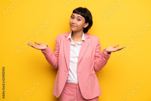 Modern woman with pink business suit having doubts while raising hands and shoulders