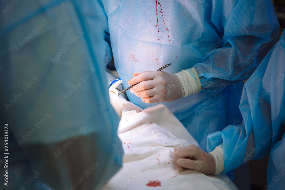 Close-up hands, team of doctors during surgery, surgical instruments on a table Close-up hands, team of doctors during surgery, surgical instruments on a table
