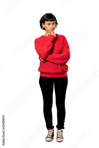 A full-length shot of a Short hair girl with red sweater thinking over isolated white background