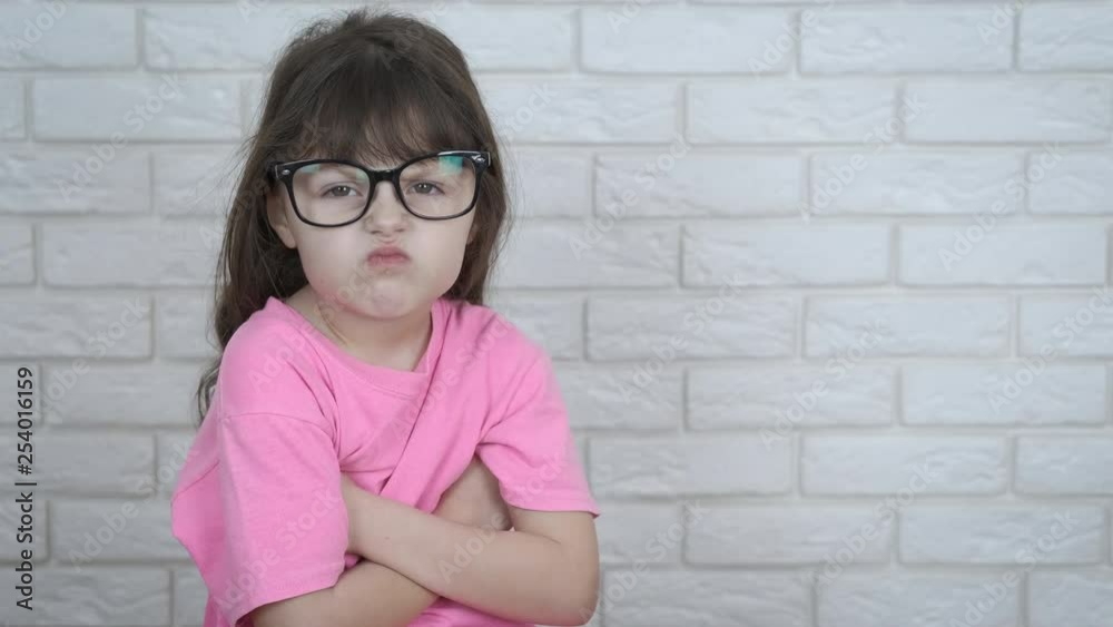 An angry child. Funny little girl with glasses is angry. An angry child. Funny little girl with glasses is angry.