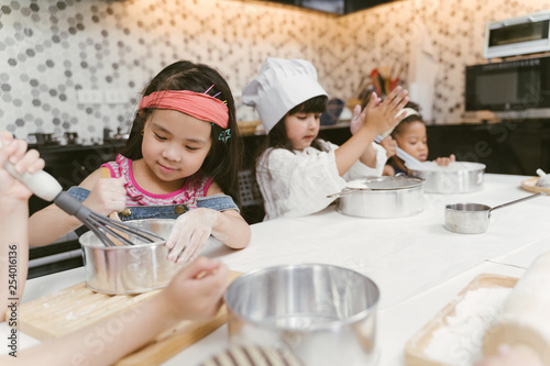 Group of kids are preparing the bakery in the kitchen .Children learning to cooking cookies