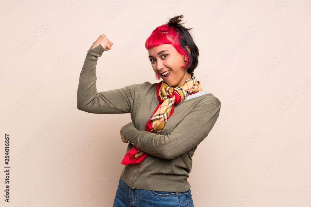 Young woman with pink hair over yellow wall doing strong gesture Young woman with pink hair over yellow wall doing strong gesture