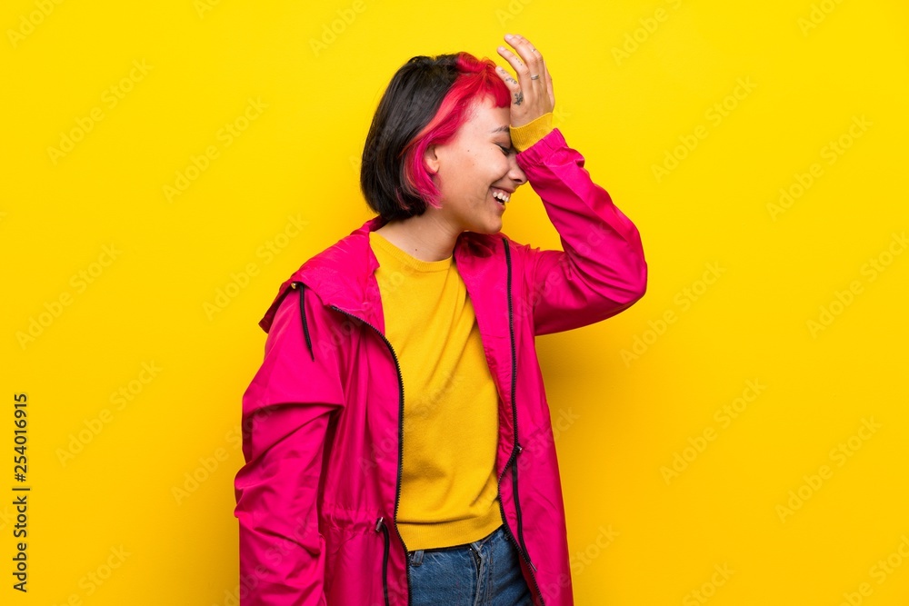 Young woman with pink hair over yellow wall has realized something and intending the solution