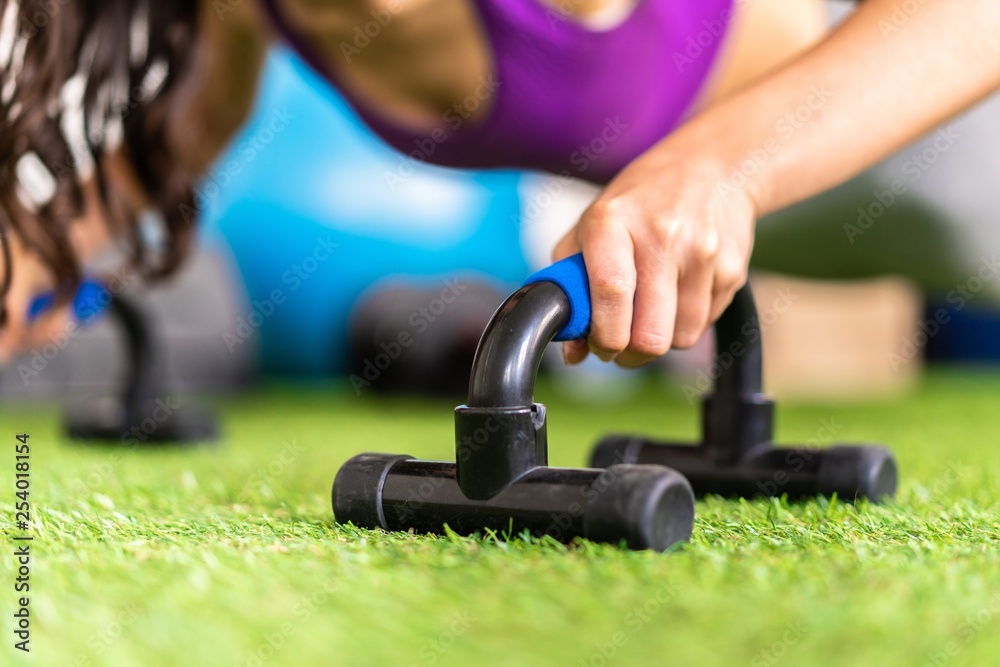 Young sport woman in a gym doing push-ups Young sport woman in a gym doing push-ups