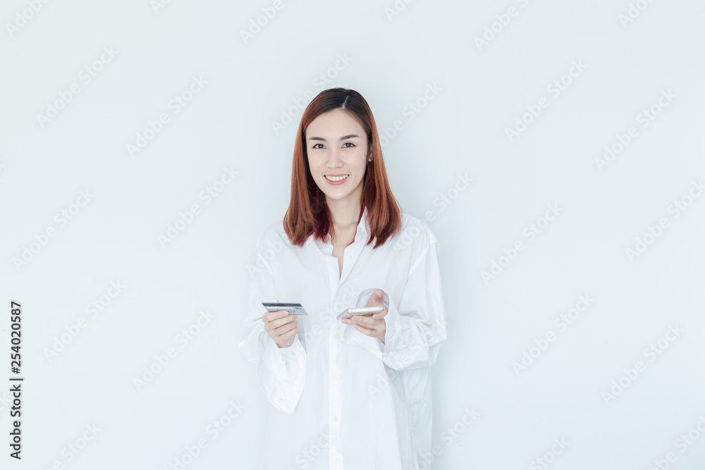 Young woman holding credit card and using mobile phone. Online shopping concept Young woman holding credit card and using mobile phone. Online shopping concept