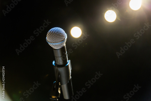 Wireless microphone on the stand on the background of spotlights on the stage.