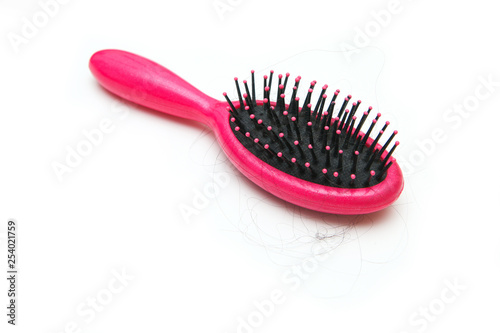 Pink hairbrush with some hair on it. Symbolises the hair loss of woman. 