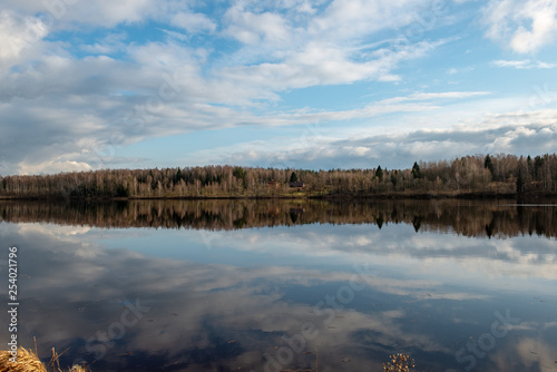 riverside landscape in latvia with dark water and dirty shore line