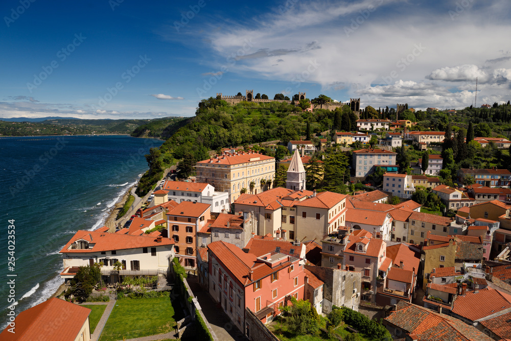 Aerial of Piran Slovenia on Gulf of Trieste Adriatic sea with St Francis of Assisi church bell tower and ancient Town Walls on hilltop