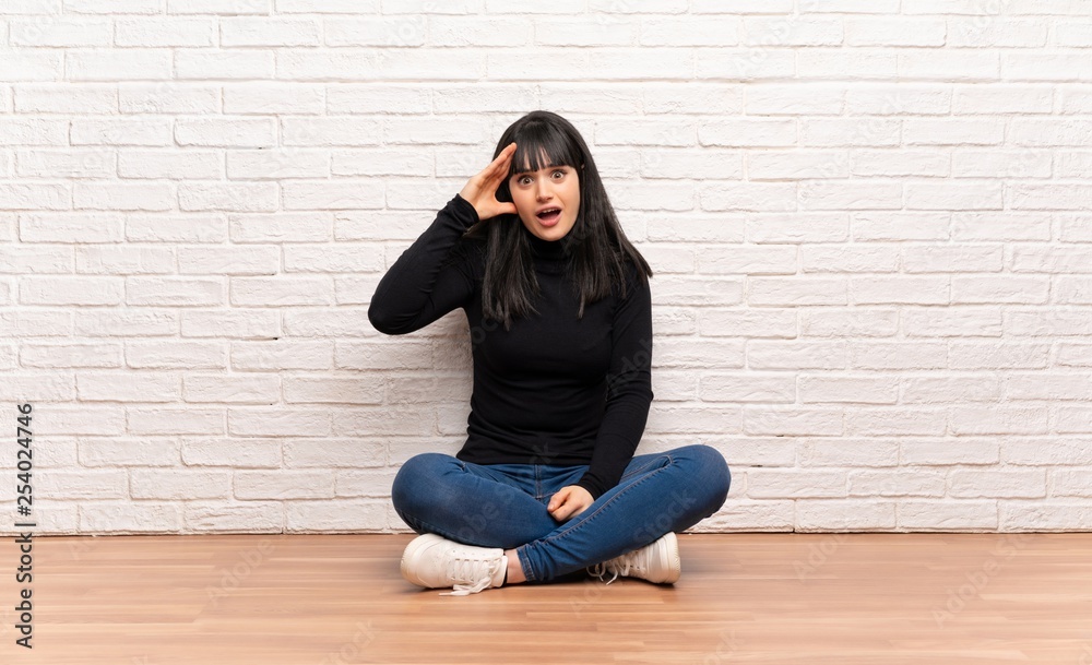 Woman sitting on the floor has just realized something and has intending the solution Woman sitting on the floor has just realized something and has intending the solution