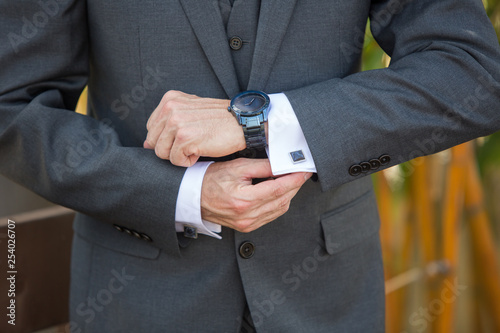 Man adjusting his cufflinks wearing a watch © Phase4Photography