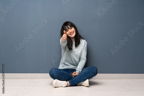 Woman sitting on the floor shaking hands for closing a good deal