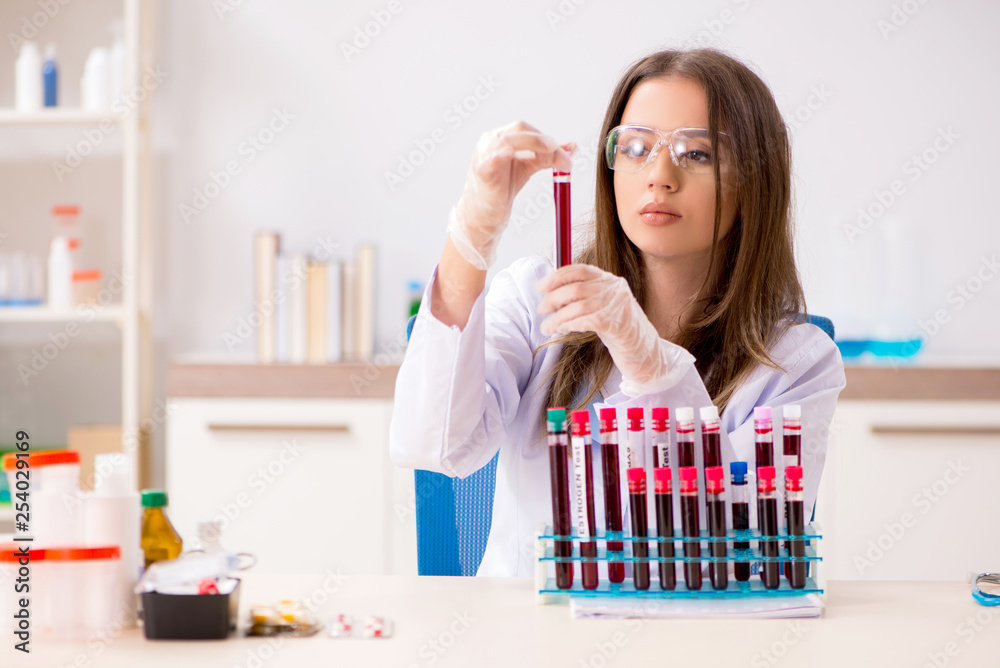 Young beautiful lab assistant testing blood samples Young beautiful lab assistant testing blood samples