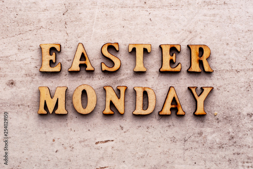 Inscription EASTER MONDAY in wooden letters on a light background