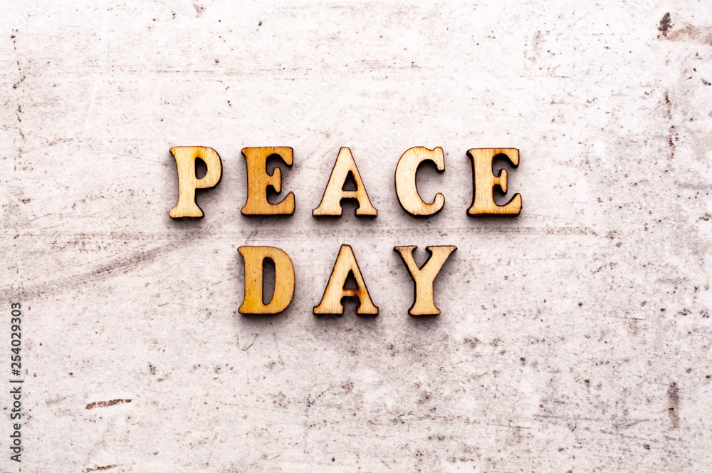 Inscription PEACE DAY in wooden letters on a light background Inscription PEACE DAY in wooden letters on a light background