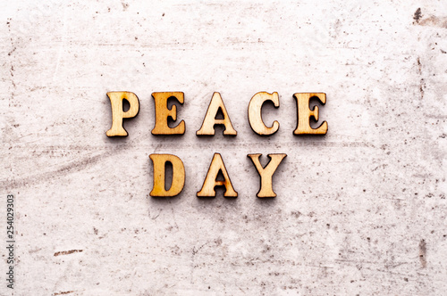 Inscription PEACE DAY in wooden letters on a light background