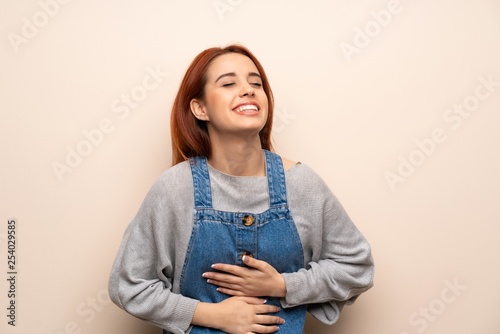 Young redhead woman over isolated background smiling a lot while putting hands on chest