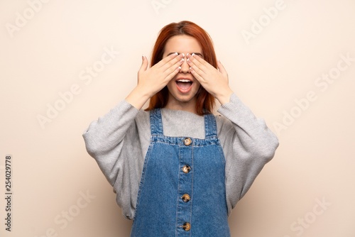 Young redhead woman over isolated background covering eyes by hands. Surprised to see what is ahead