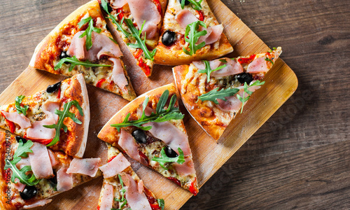 Wallpaper Mural Pizza with Mozzarella cheese, ham, pepper, olive, meat, Tomato sauce, Spices and Fresh arugula. Italian pizza on wooden background Torontodigital.ca