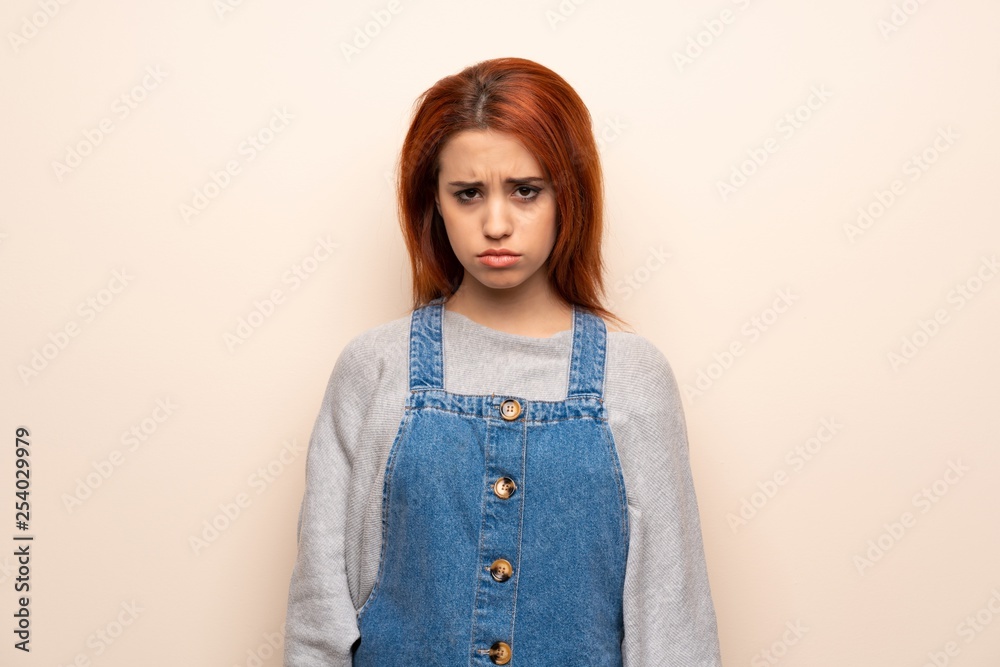 Young redhead woman over isolated background with sad and depressed expression Young redhead woman over isolated background with sad and depressed expression